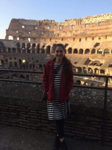 girl standing before coliseum ruins in Rome