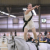 iSVA's Gracelyn Rogers competes in equestrian National Championship; pictured riding a horse and pointing at the crowd