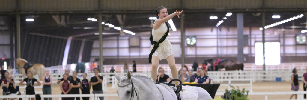 iSVA's Gracelyn Rogers competes in equestrian National Championship; pictured riding a horse and pointing at the crowd